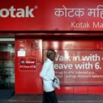 A person using a credit card for international shopping, representing kotak mahindra bank services.