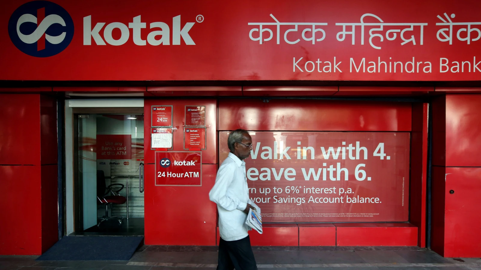 A person using a credit card for international shopping, representing kotak mahindra bank services.