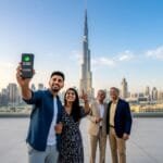 Indian tourist using a smartphone to book a trip to the Burj Khalifa in Dubai